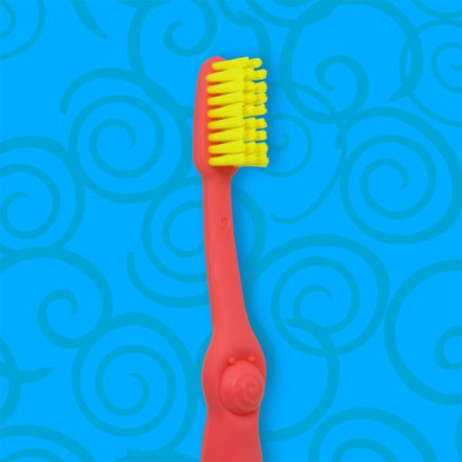 Detalle de cepillo dental infantil con mango color rosa