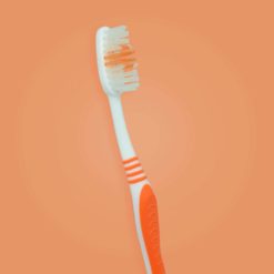 Perspectiva de cepillo dental para adultos con mango color naranja
